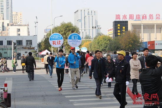 河南交通廣播的主持人們引導(dǎo)過(guò)馬路的行人從斑馬線通行