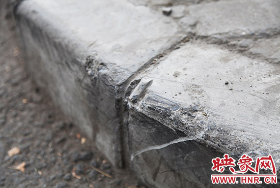 車道邊上的臺階，滿是電動車摔下碰撞的痕跡