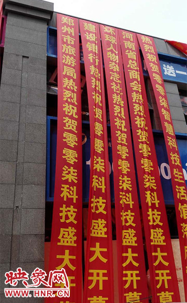 路邊一棟樓上懸掛著二三十條紅色條幅，全部是祝賀一家公司開業(yè)的。