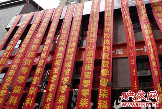 路邊一棟樓上懸掛著二三十條紅色條幅，全部是祝賀一家公司開業(yè)的。