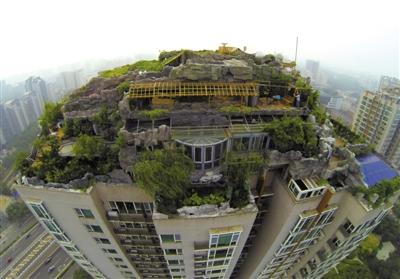 　　昨日，身穿橘黃色馬甲的工作人員在人濟(jì)山莊樓頂拆除違章建筑。新京報(bào)記者 吳江 攝