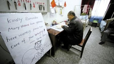 張大爺在門衛(wèi)室里工作，旁邊是紅爆網(wǎng)絡(luò)的溫馨提示牌記者