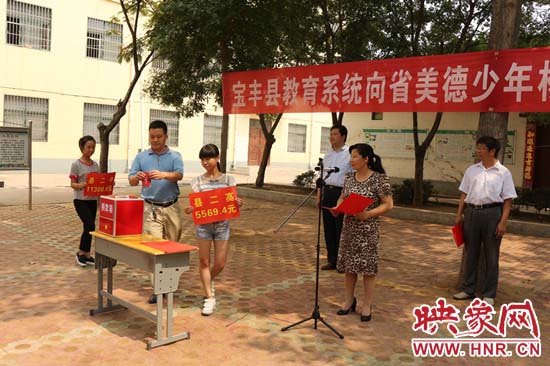 寶豐縣教育系統(tǒng)全體人員在石橋鎮(zhèn)中學(xué)為“美德少年”楊冠明同學(xué)捐款。