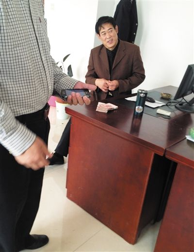 10月29日，獻(xiàn)縣國(guó)稅局稽查局辦公室內(nèi)，一名企業(yè)主交了兩萬(wàn)元現(xiàn)金在桌上。新京報(bào)記者 孟祥超 攝