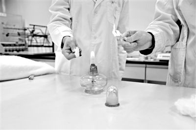 實驗人員操作的燃燒檢測法中，真蠶絲離開火焰就熄滅(左)。