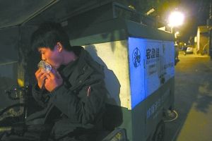 快遞哥抽空吃兩口東西。記者 李剛 攝