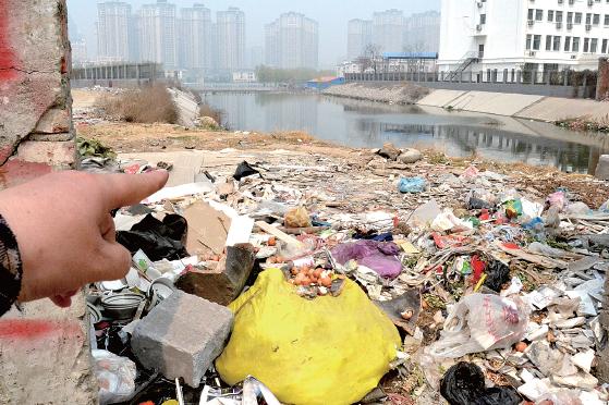 金水河長江路橋下河水發(fā)臭，水邊堆放眾多垃圾
