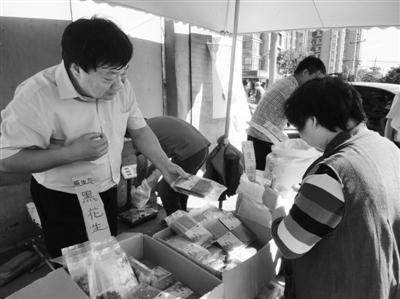 昨日，河南企業(yè)家劉春喜在京“練攤”，為顧客挑選綠豆。新京報(bào)記者 張玉學(xué) 攝