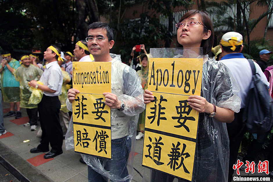 　圖為當(dāng)天下午，當(dāng)臺(tái)灣數(shù)百漁民在馬尼拉經(jīng)濟(jì)文化辦事處前抗議時(shí)，有兩名年輕人手持標(biāo)語(yǔ)，在路邊聲援。中新