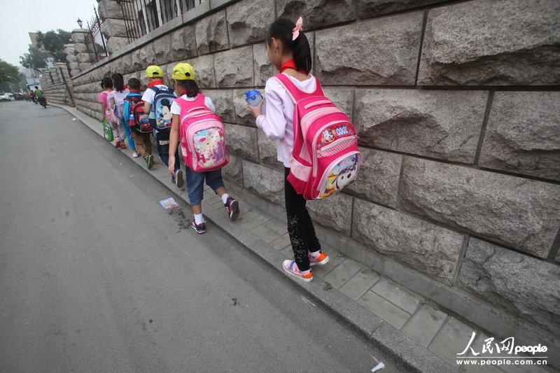 2013年09月11日，濟(jì)南運(yùn)署街上，小學(xué)生走史上“最窄人行道”上學(xué)。