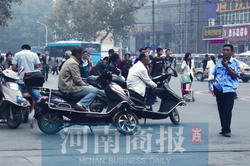 　火車站廣場北側(cè)，幾輛摩的正在等客