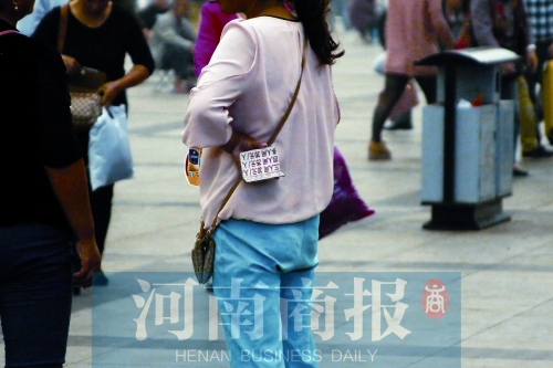 火車站廣場，一女子拿著寫有不同房型價(jià)位的卡片在拉客，不少市民抱怨，受過此類“騷擾”