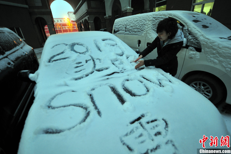 11月18日，行人在車輛的積雪上涂鴉。