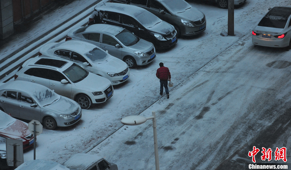 11月18日，行人在沈陽街頭的積雪中穿行。