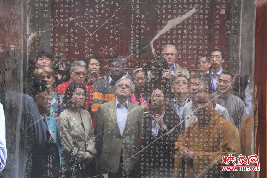 在一塊石碑前，少林寺方丈正在講解