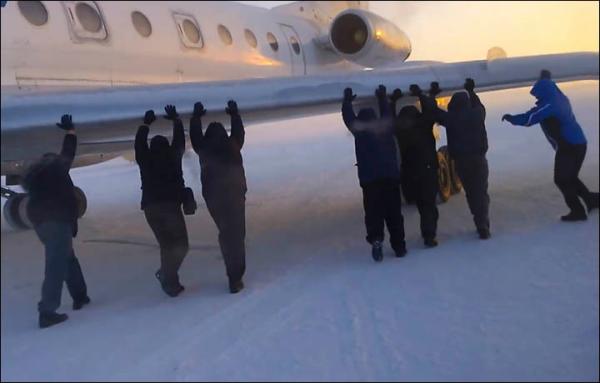 伊加爾市一架客機起飛前被凍在了跑道上。飛機上的乘客不得不下來推飛機。