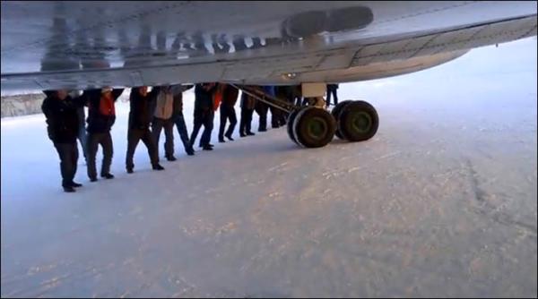 　伊加爾市一架客機起飛前被凍在了跑道上。飛機上的乘客不得不下來推飛機。