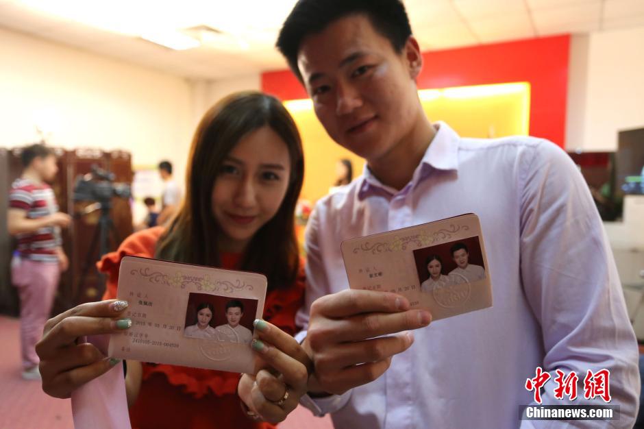 5月20日,河南鄭州,一對(duì)準(zhǔn)新人領(lǐng)完結(jié)婚證后秀自拍。