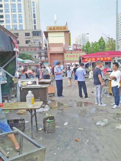 昨天，執(zhí)法人員在京廣路長江路口整治“僵尸圍擋”及圍擋內(nèi)的攤販。