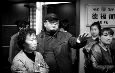 昨日，在河北香河天下第一城，相關負責人（左二）走出會議室與參加演出的老人們溝通。