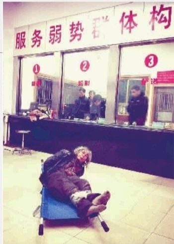 1月7日23點50分，長沙市救助管理站大廳，一名老年流浪者躺在擔架上，無助地看著記者。