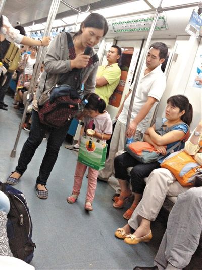 6月27日，舒馨帶一女孩在地鐵十號(hào)線行乞。她因被疑帶多個(gè)不同小孩乞討被警方搜尋。新京報(bào)記者 申志民 攝