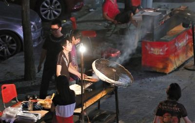 7月4日，青年路國美第一城小區(qū)附近的夜市臨街露天燒烤攤。
