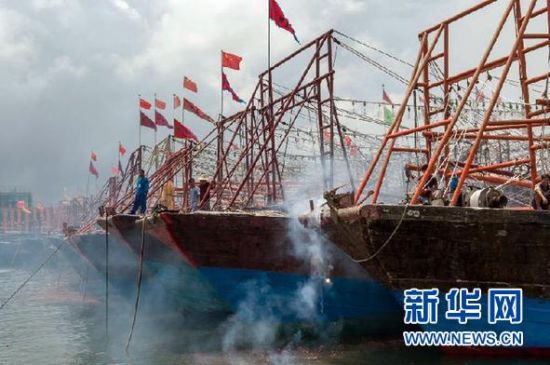 2013年8月1日 南海開漁日 臨高迎新港 8月1日，海南省臨高縣漁民在船上鳴放鞭炮慶祝武蓮港開港。
