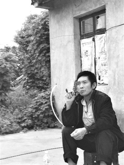 9月12日，陳文才在自己的出租屋旁抽煙。新京報(bào)記者 朱柳笛 攝