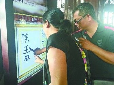 　圖為一對游客夫妻在“涂鴉”。