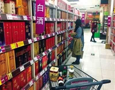 顧客在商場(chǎng)的高檔白酒貨架前駐足挑選。春節(jié)臨近，受“禁令”影響，以高檔白酒為代表的節(jié)日禮品市場(chǎng)面臨考驗(yàn)。記者 王遠(yuǎn)征 攝