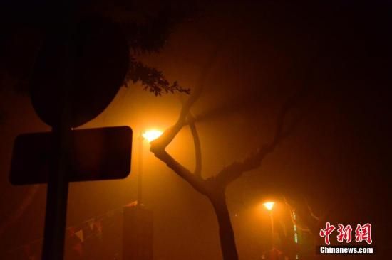1月31日凌晨，市民行走在煙霧繚繞的南京街頭。當(dāng)天是農(nóng)歷馬年正月初一，南京有限開(kāi)禁燃放煙花爆竹正逢下霧天，空氣的不流通致使煙花爆竹燃燒后產(chǎn)生的顆粒物不能及時(shí)散開(kāi)，造成整座城市煙霧繚繞。據(jù)當(dāng)?shù)丨h(huán)保部門(mén)發(fā)布的信息顯示，空氣質(zhì)量屬重度污染。中新社發(fā) 泱波 攝