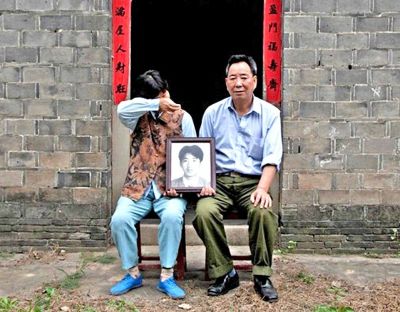 江蘇鎮(zhèn)江，老劉夫婦捧著獨(dú)生子的遺像在老家前留影南方都市報(bào)供圖L