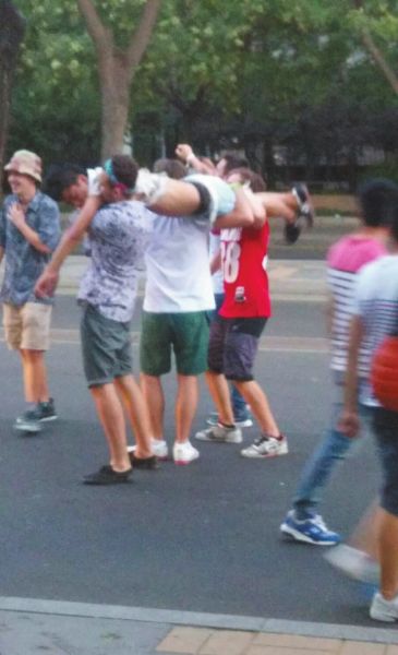 　四名外籍男子一同扛起醉漢拍照。
