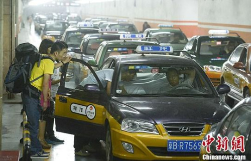 市民在北京西客站出租車候車點準備乘車。中新社發(fā) 侯宇 攝