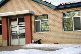 伊春市帶嶺區(qū)一排破舊的平房，房間窗戶上貼滿了“我告饒了”的字樣。