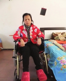 陳慶霞坐在輪椅上。她現(xiàn)在下身癱瘓，疾病纏身，生活不能自理。