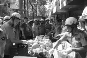 7月11日，瀏陽市北正中路，執(zhí)法人員暫扣張海的水果。這是瀏陽市城管局拍攝的執(zhí)法現(xiàn)場圖。