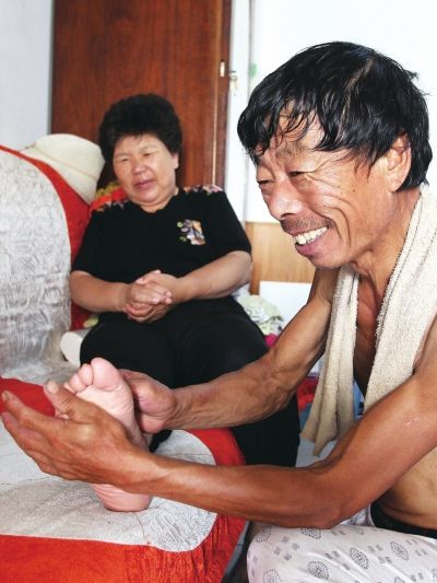 慈成富為老伴按摩。