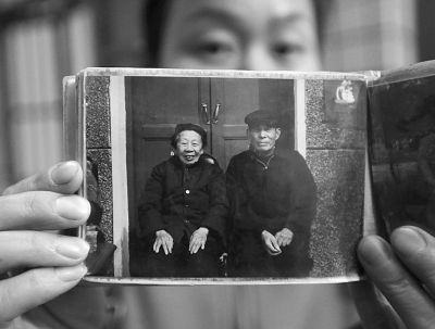 圖為孫女拿出兩位老人上世紀80年代在家門口的合影給記者看。記者楊濤 攝