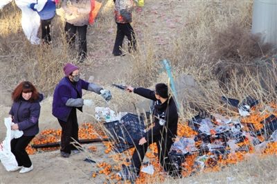 1月4日，連霍高速蘭州市榆中縣和平鎮(zhèn)段，一名警察舉著槍驅散哄搶橘子的村民。圖/CFP