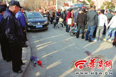 車禍現(xiàn)場的血跡被人用土覆蓋，旁邊則放著紅領(lǐng)巾、一雙童鞋和一頂帽子 本報(bào)記者 趙彬 攝