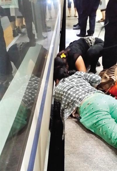 一女子趴在站臺(tái)上，救跌入列車和站臺(tái)間隙的男童。網(wǎng)友璀璨的星月夜 攝
