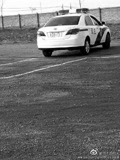 一輛車牌號 為“ 陜DD173”的制式警車停在一個劃著白線的場地上，車身標有“司法”字樣