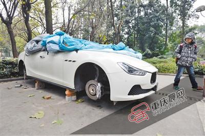 昨日，停放在重慶大學(xué)B區(qū)的一輛瑪莎拉蒂豪車被架在幾塊磚頭上，車輪不翼而飛。 重慶晨報(bào)記者 胡杰 攝