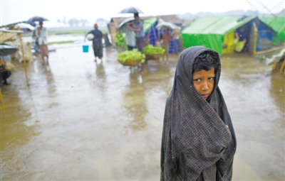 5月14日，緬甸若開邦實(shí)兌難民營，羅興亞族難民在雨中行走。熱帶風(fēng)暴“馬哈森”即將登陸緬甸，這里的難民開始乘船撤離。