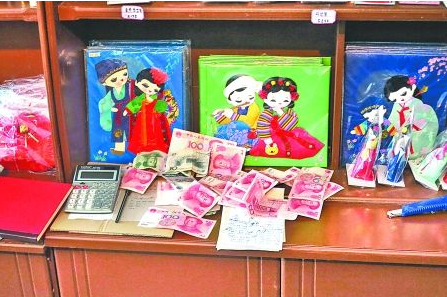 　　2012年6月21日，在朝鮮羅先特別市的一家商店里，柜臺上散落著一些人民幣。在朝鮮，人民幣比本國