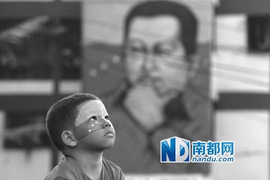 3月5日，一名委內(nèi)瑞拉兒童仰望天空，他身后是查韋斯的陵墓。