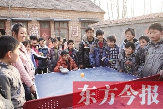 坐著輪椅的小宗成和同學(xué)們一塊打乒乓球，這是他感到最快樂(lè)的事