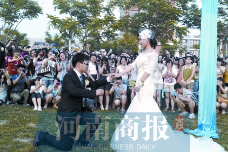 在學(xué)校操場的草坪上，兩名畢業(yè)生舉行婚禮，有同學(xué)感動(dòng)地抹起眼淚